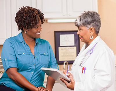 Doctor conducts medical consultation with adult patient at clinic.