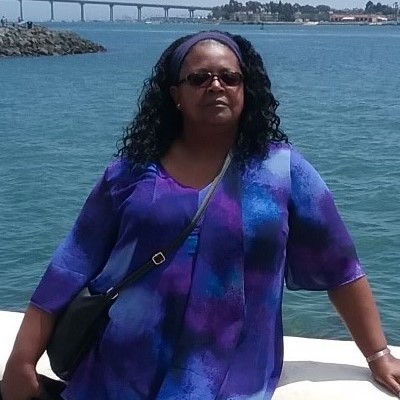 Nurse Debra C standing outside by the water.