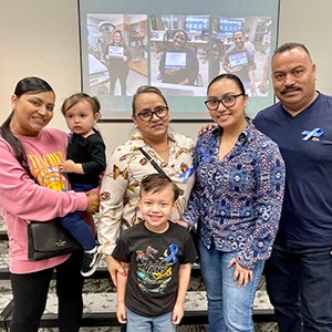 Second from right, former trauma center patient Stacey Perez smiles while posing with her parents and children. 