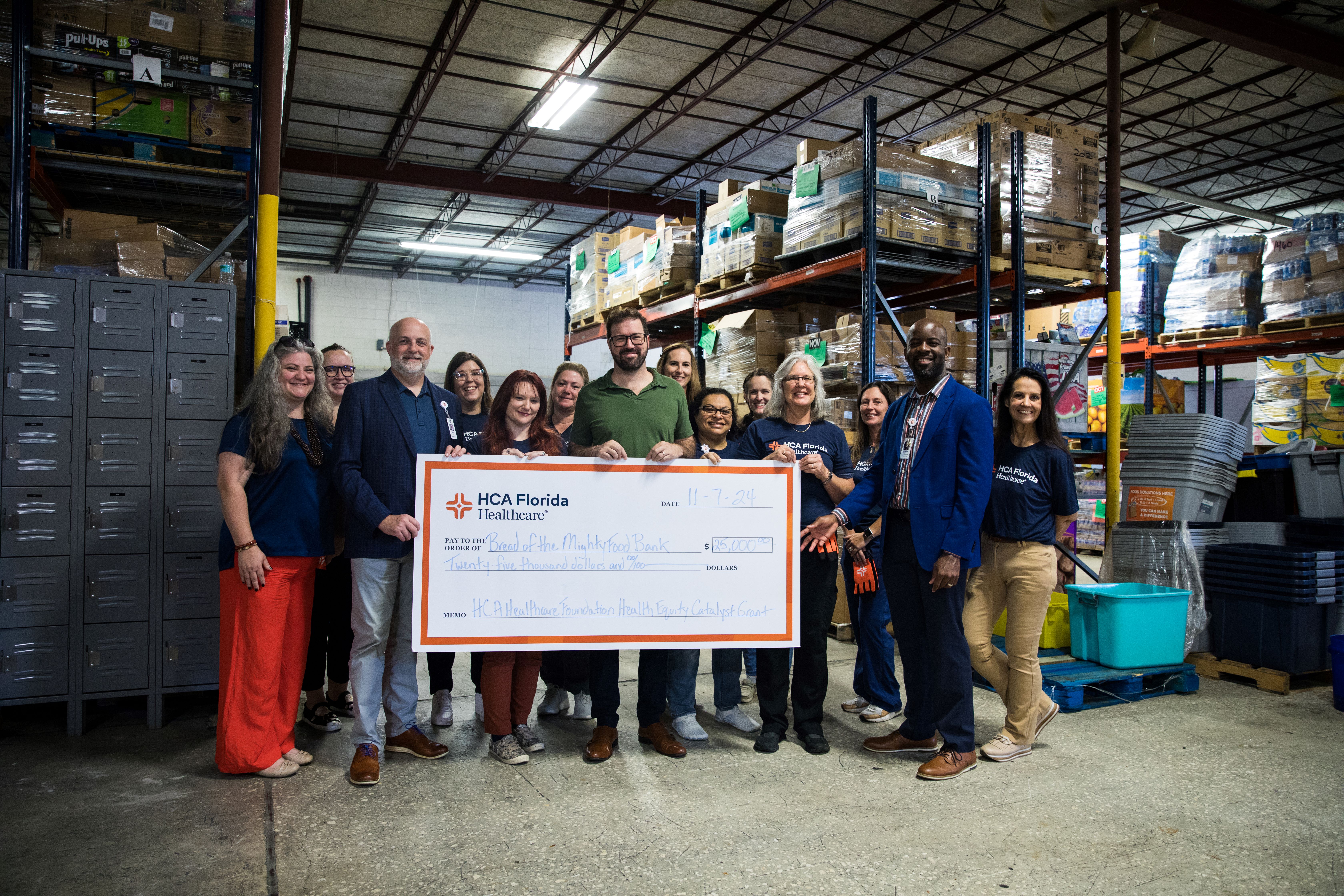 HCA Florida North Florida Hospital colleagues presenting a check for $25,000 to Bread of the Mighty Food Bank.