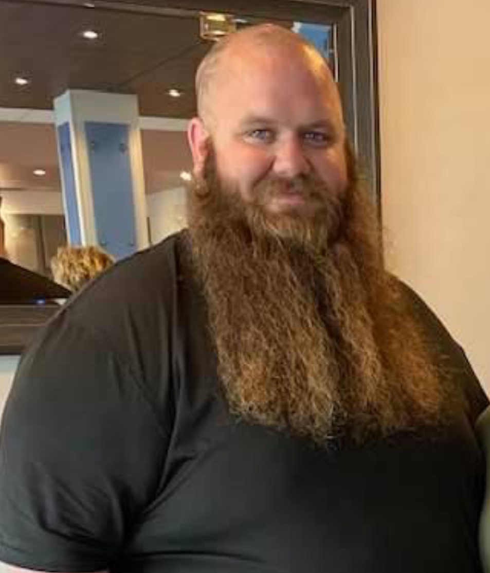 Man stands smiling before his bariatric surgery.