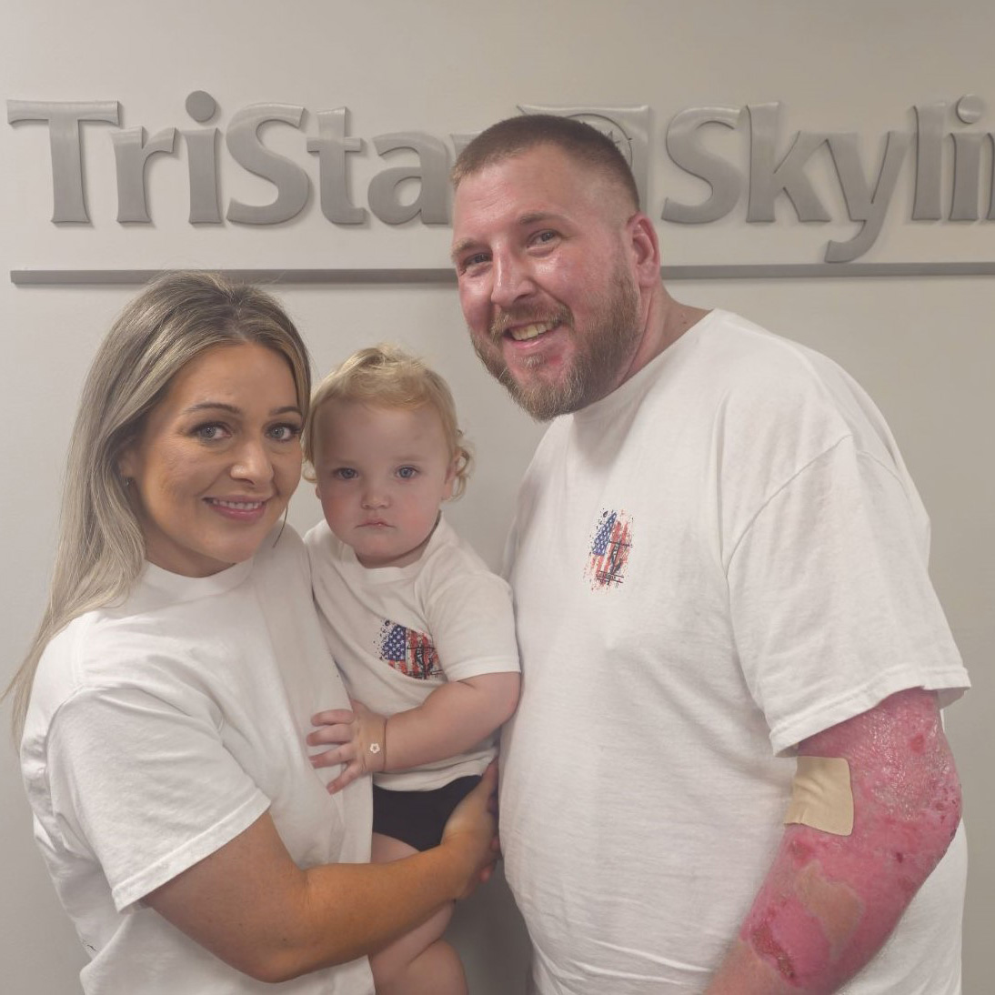 patient and his wife and child around a TriStar Skyline sign