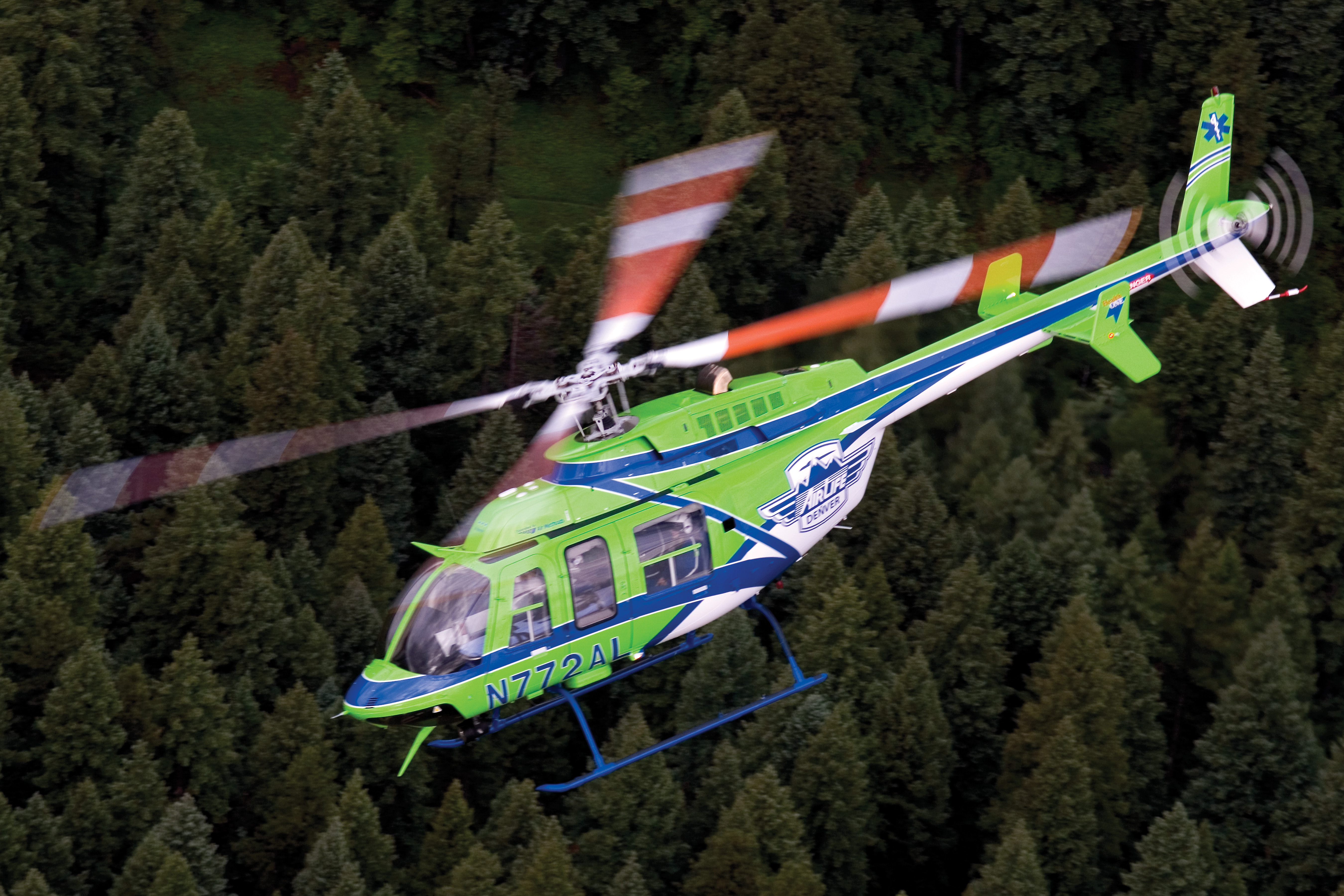 AirLife Denver air ambulance flying over a forest 