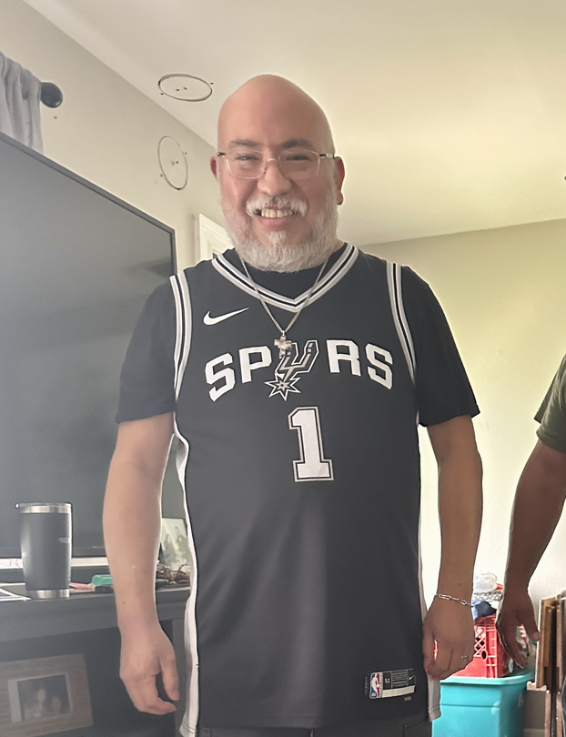 Carlos Tristan standing up wearing a San Antonio Spurs jersey