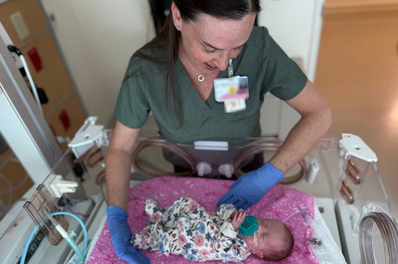 A nurse tending to a baby in the NICU