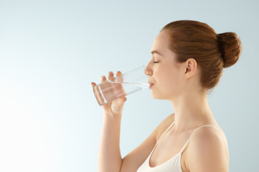 A woman drinking a glass of water.