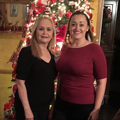 Hermelinda “Melly” Laurel and her daughter Loreena joyfully pose in front of a Christmas tree.