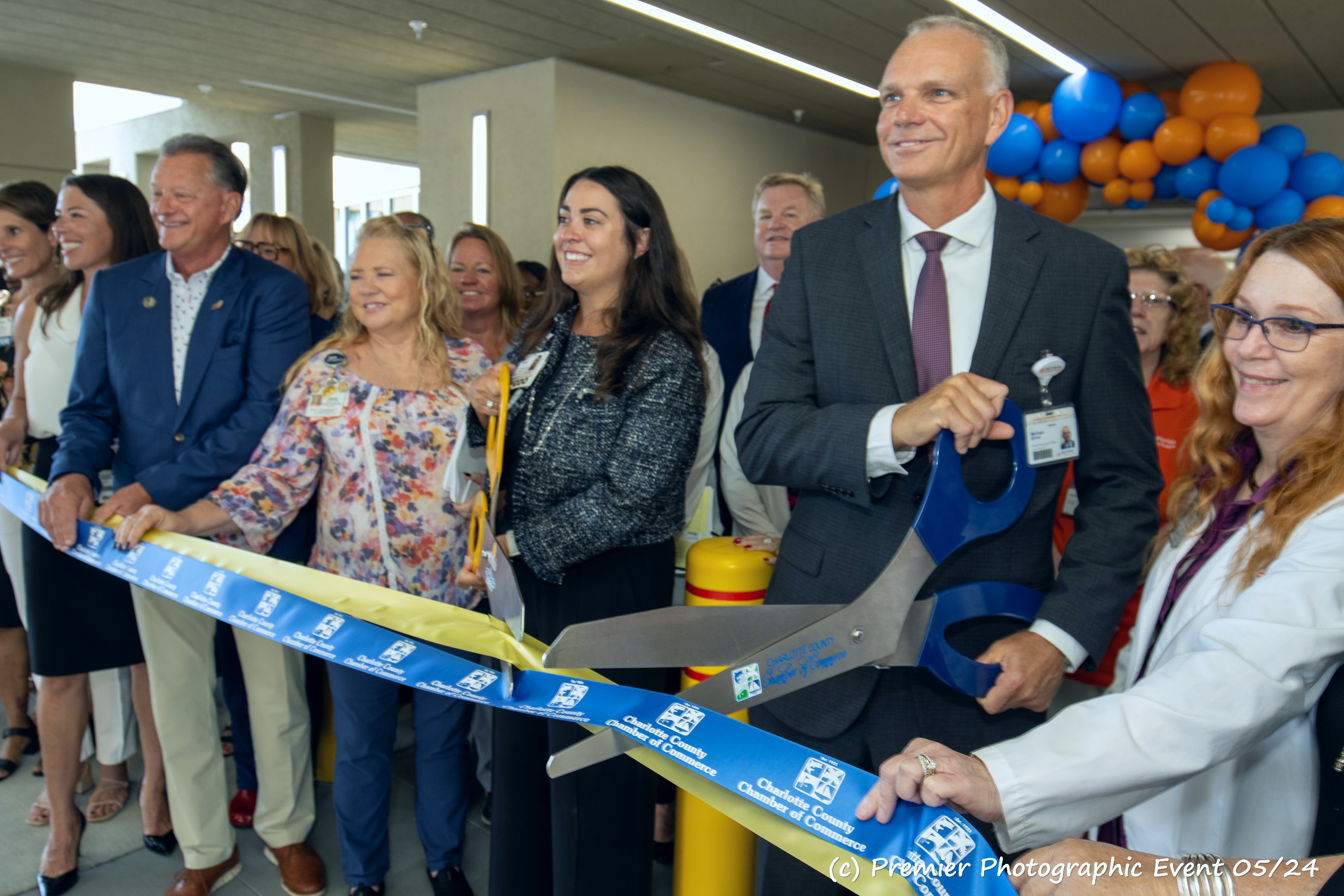 Michael Ehrat holds large sissors to cut ribbon.