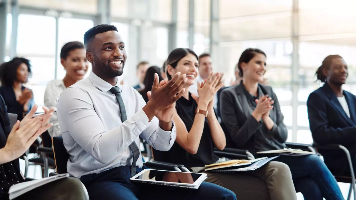 A group of seated people are applauding