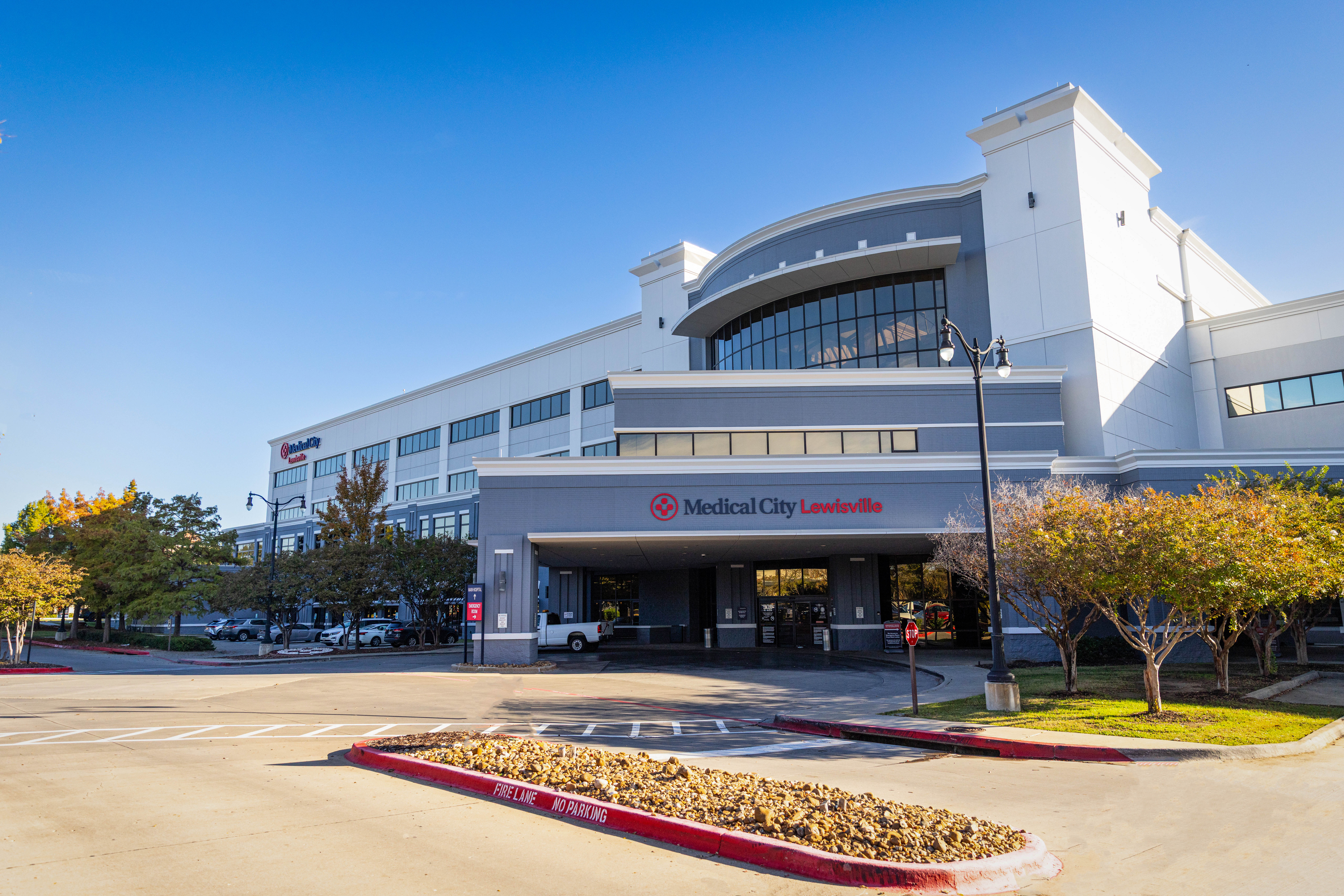 Main entrance of Medical City Lewisville Hospital, showing parking lot and patient drop off area
