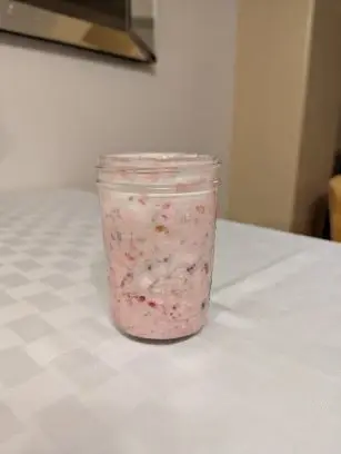 A protein shake in a mason glass sitting on a tabletop.