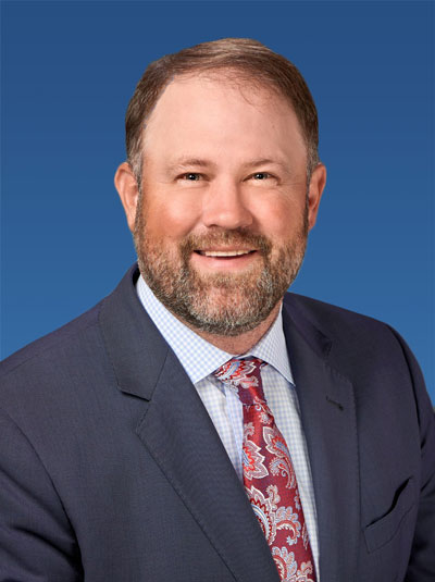 CEO Brad Talbert smiles while wearing a suit and necktie.