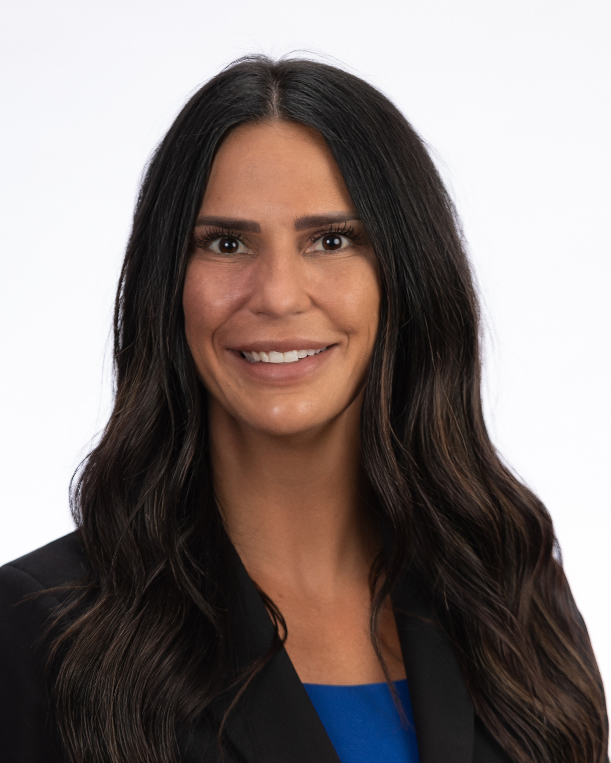 The new CEO and CNO for Cache Valley Hospital, Kelsie Green, dressed in a blue blouse with a black suit jacket, poses and smiles in her professional headshot photo.