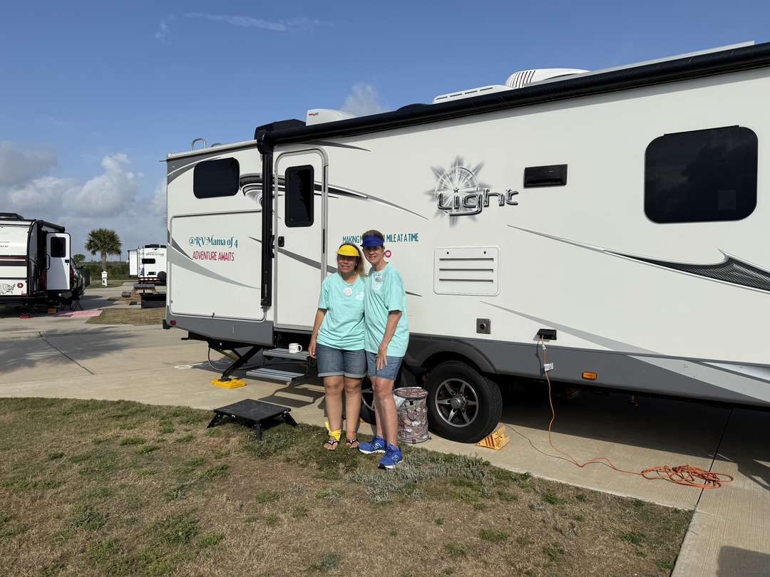 Diane and daughter standing in front of the camper.