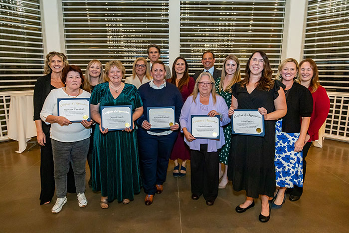 Joan Woodworth Bober, Diana Erbach, Evan Pollock, and Linda Runnals, or Frisbie Memorial Hospital. Jane Bergeron, Julie Peters, Ramona Campbell, and Amanda Packard, of Portsmouth Regional Hospital, surrounded by colleagues.