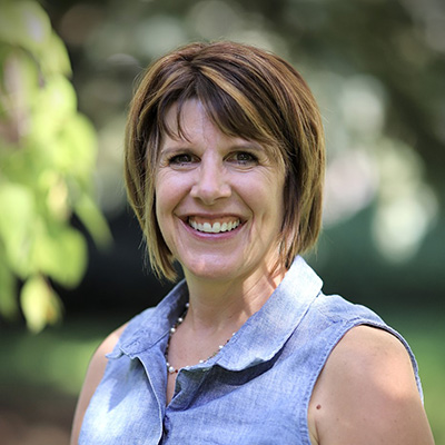 Denise Mariner smiles for the camera outdoors.