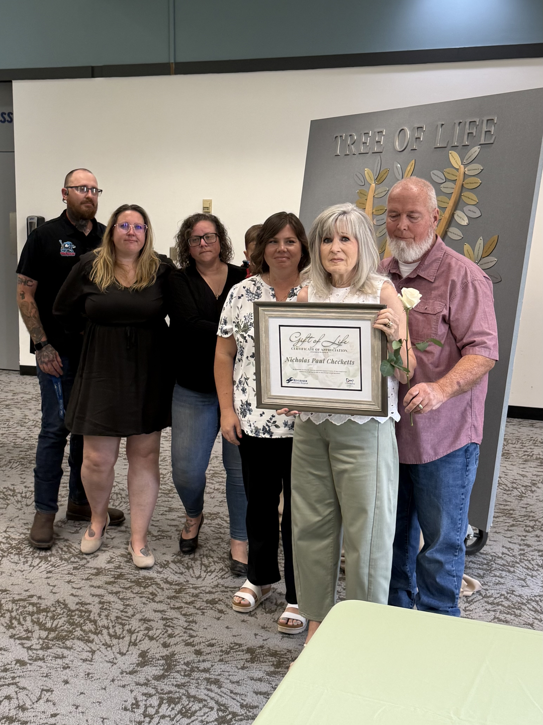 Family holds up the certificate celebrating the donor and gift of life.
