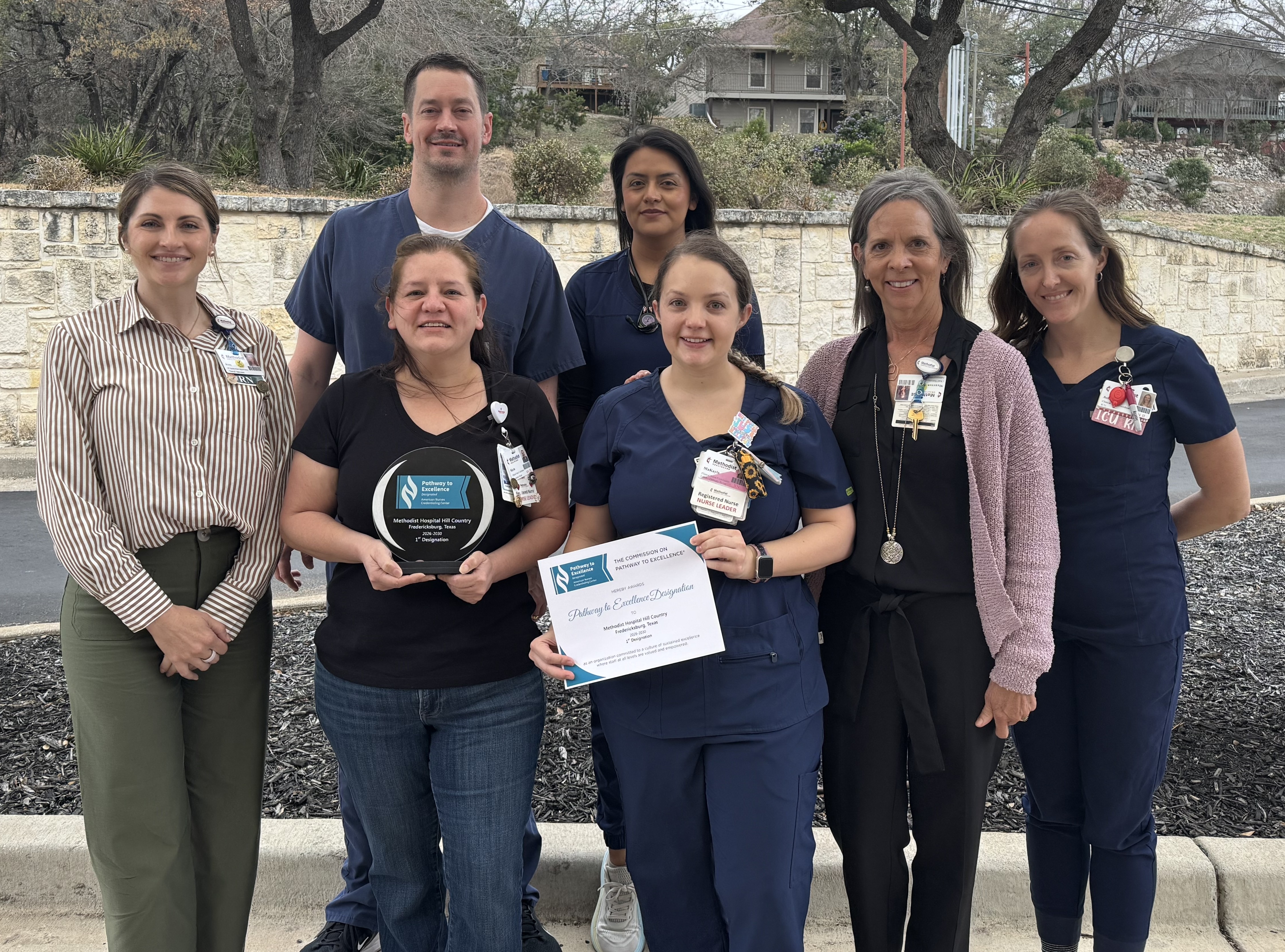 Nurse holding ACCN award with her colleagues standing beside her.