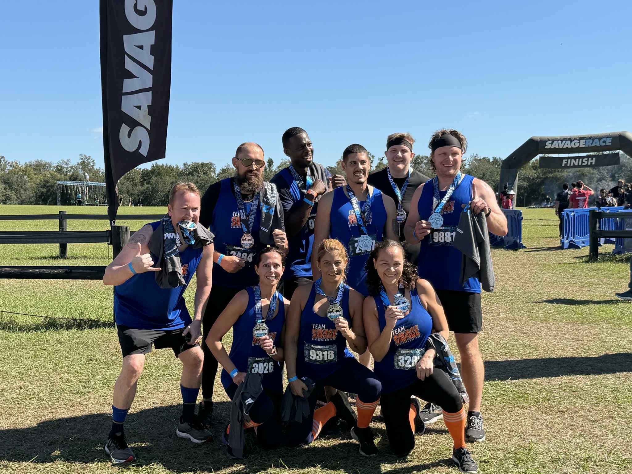 team standing smiling and holding medals