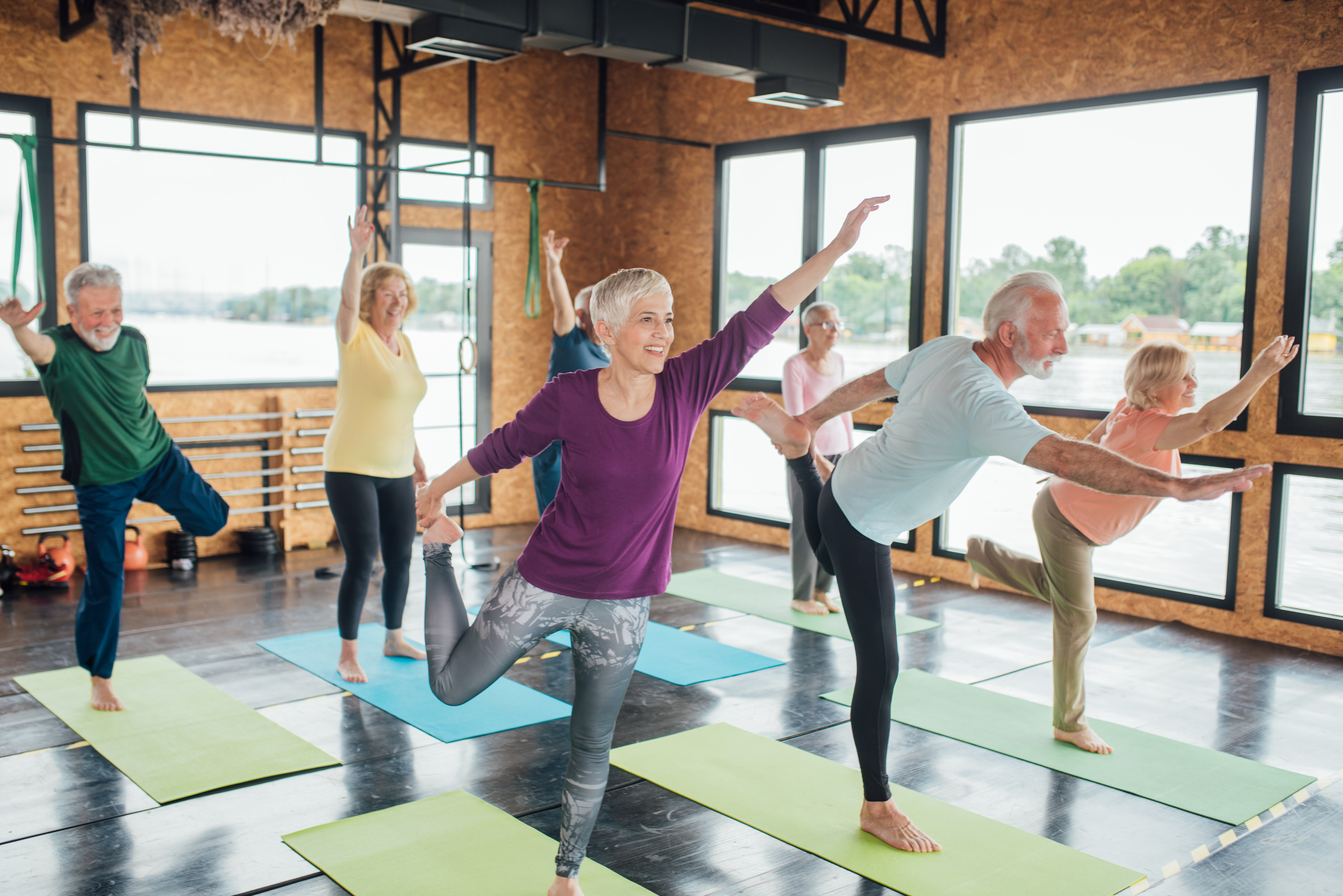 A group of seniors practicing their balance in a yoga class.