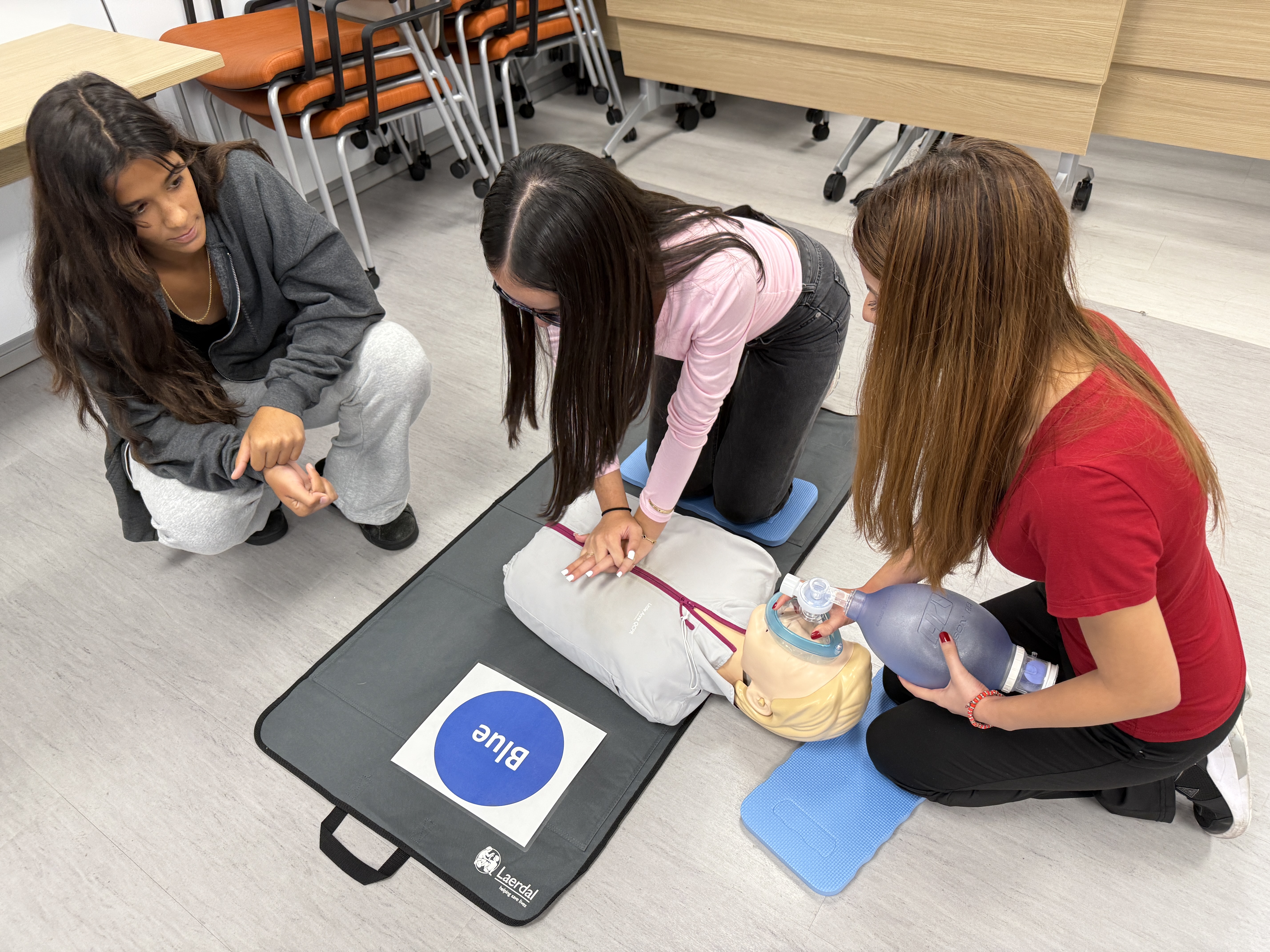 Three women are performing medical tasks as training.
