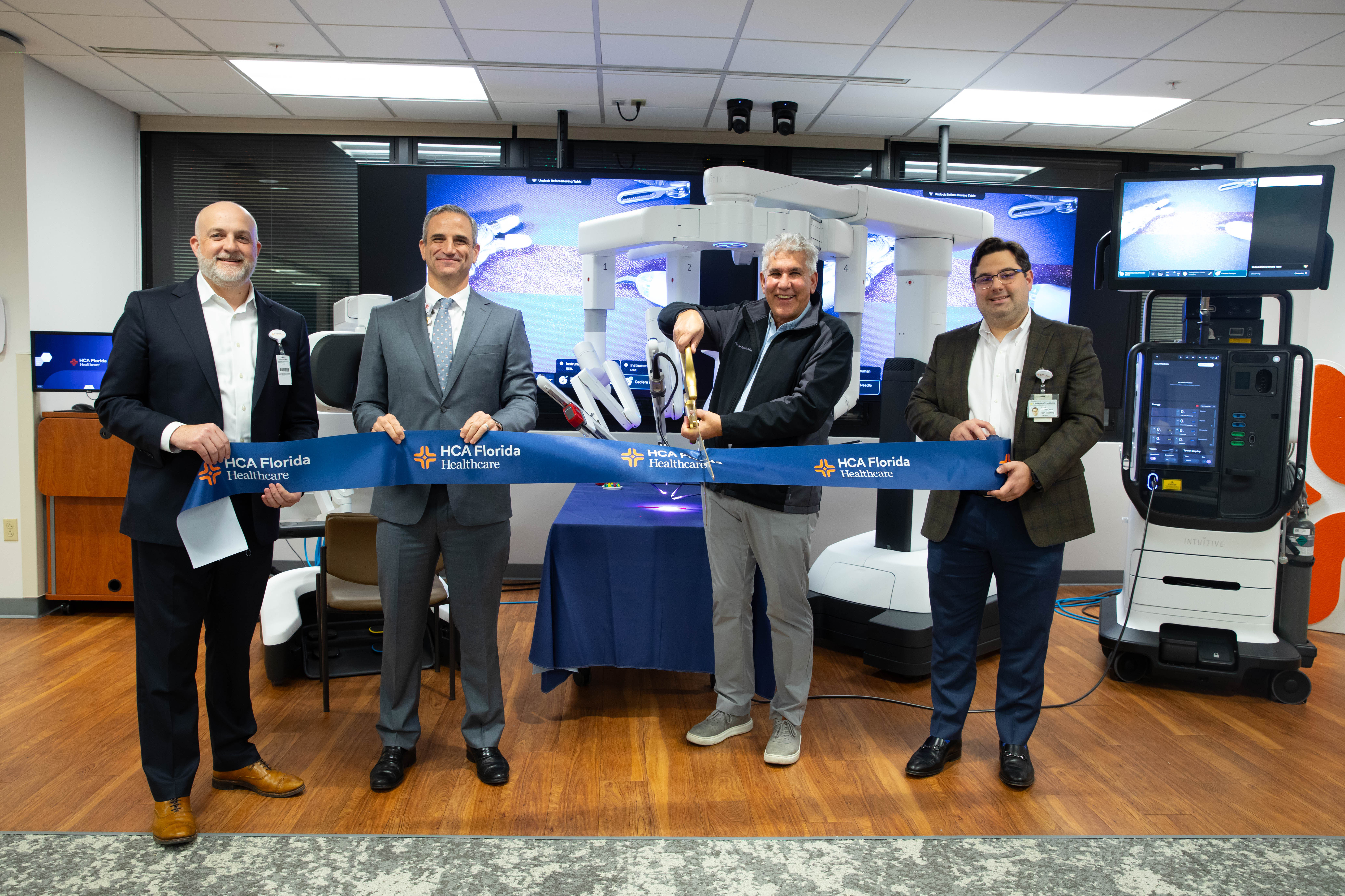 Mark Amox, Chief Operating Officer, Gabe Bullaro, Chief Executive Officer, Dr. Peter Sarantos, General Surgeon and Dr. Francisco Macedo, Surgical Oncologist, cut the ribbon on the new robotic surgical system at HCA Florida North Florida Hospital.