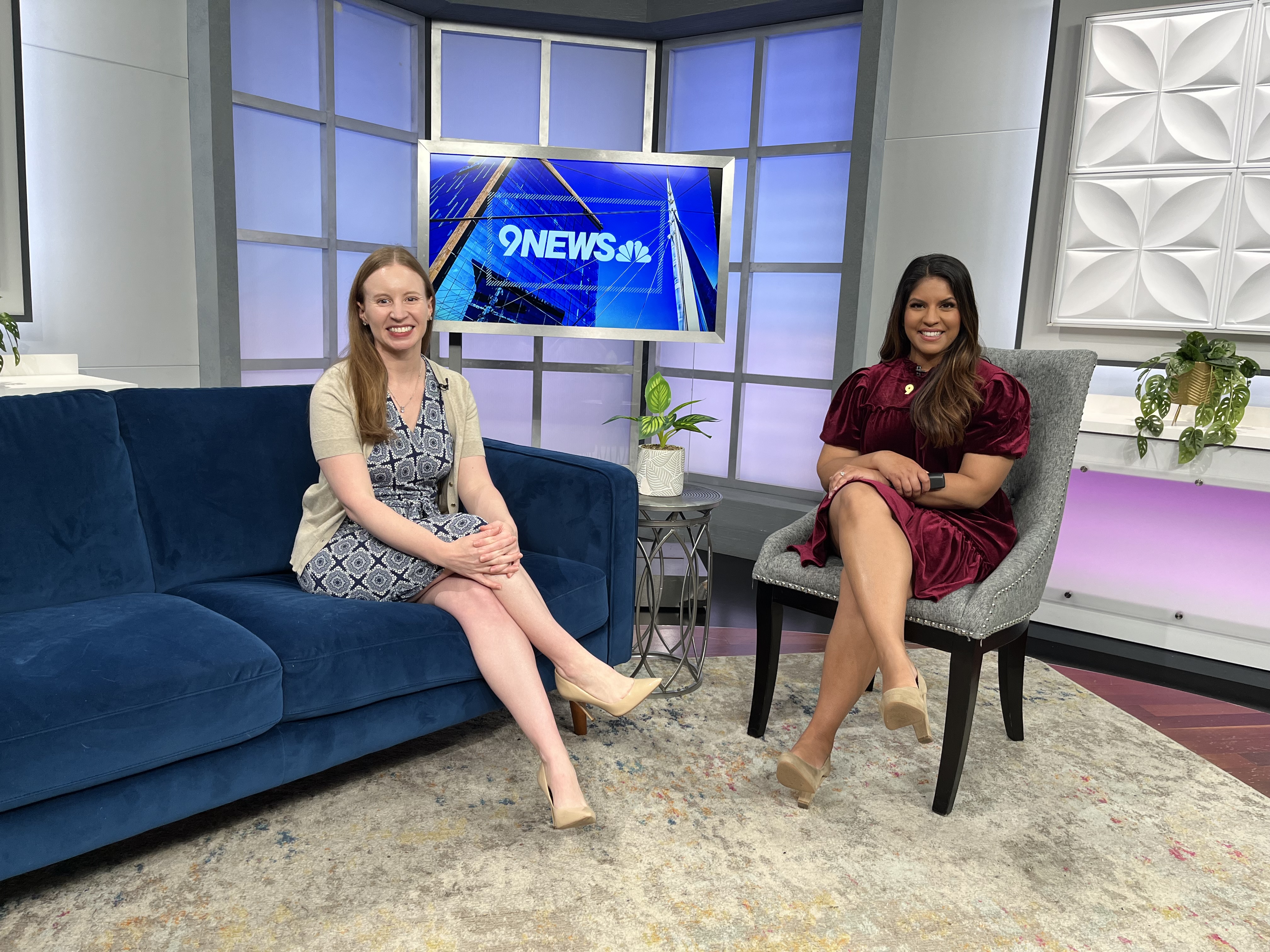 Two women on in chairs on a television production set.