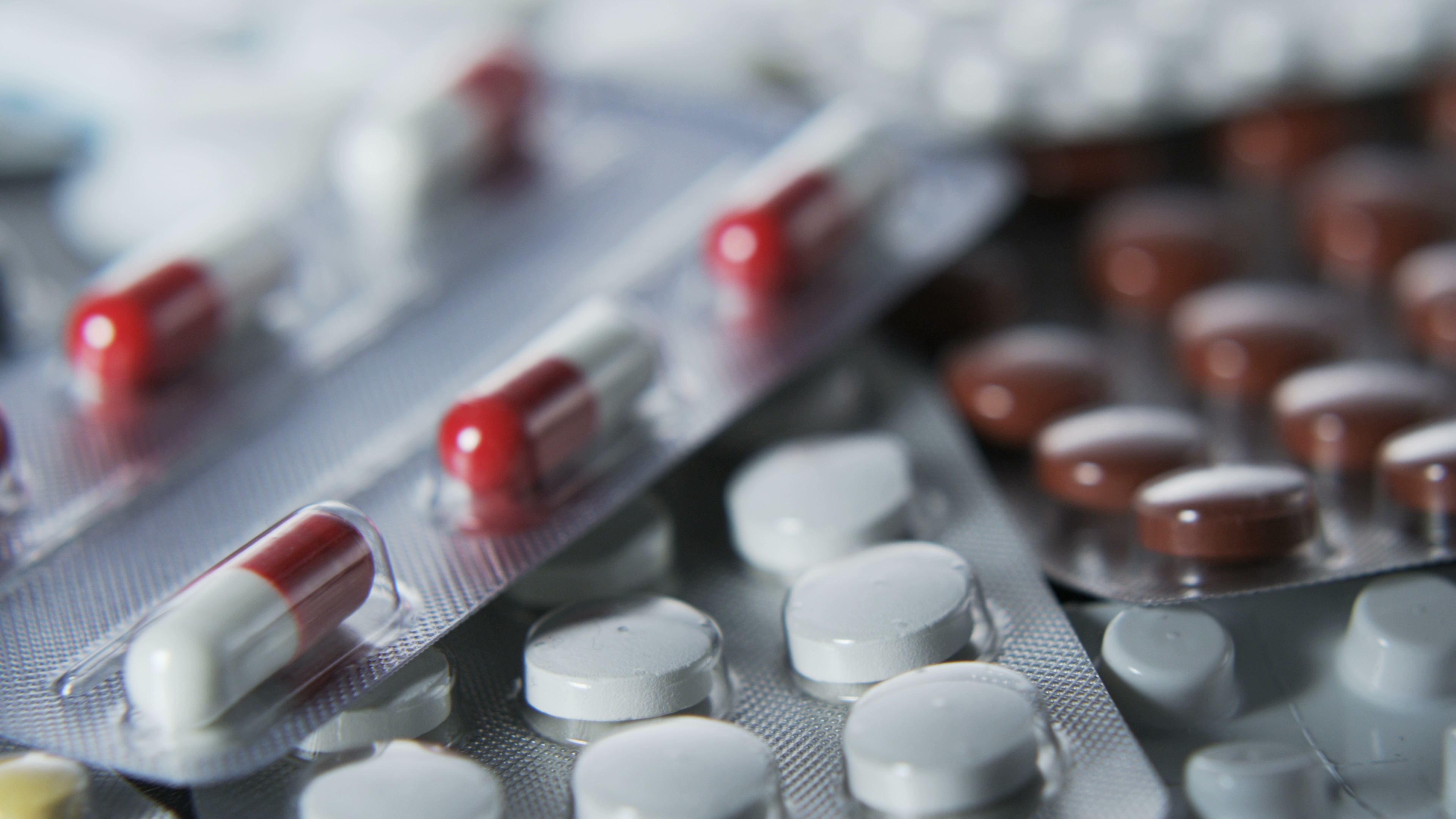 Pills and tablets in packaging stacked on top of one another