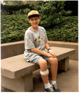 A young David Dow sits outside on a bench.