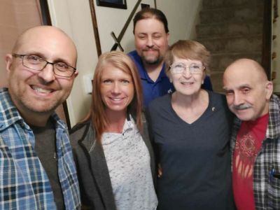 Bernice and her family smile while standing together in her home.