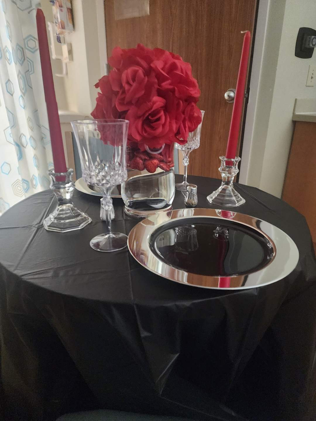Fancy Anniversary table setup, with red candles, flowers and silverware.