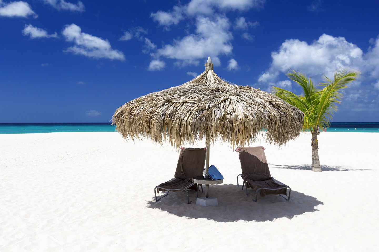 Beach chairs and a umbrella on a white sand beach