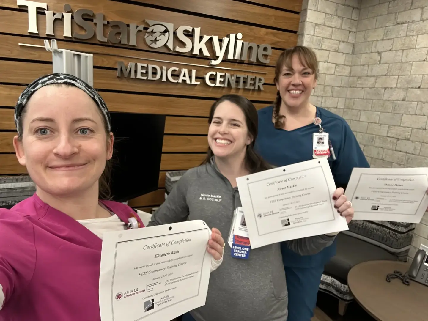 Speech language pathology team showing off their certificates.