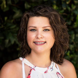 Sommer Wright smiles while wearing a floral print halter top shirt.