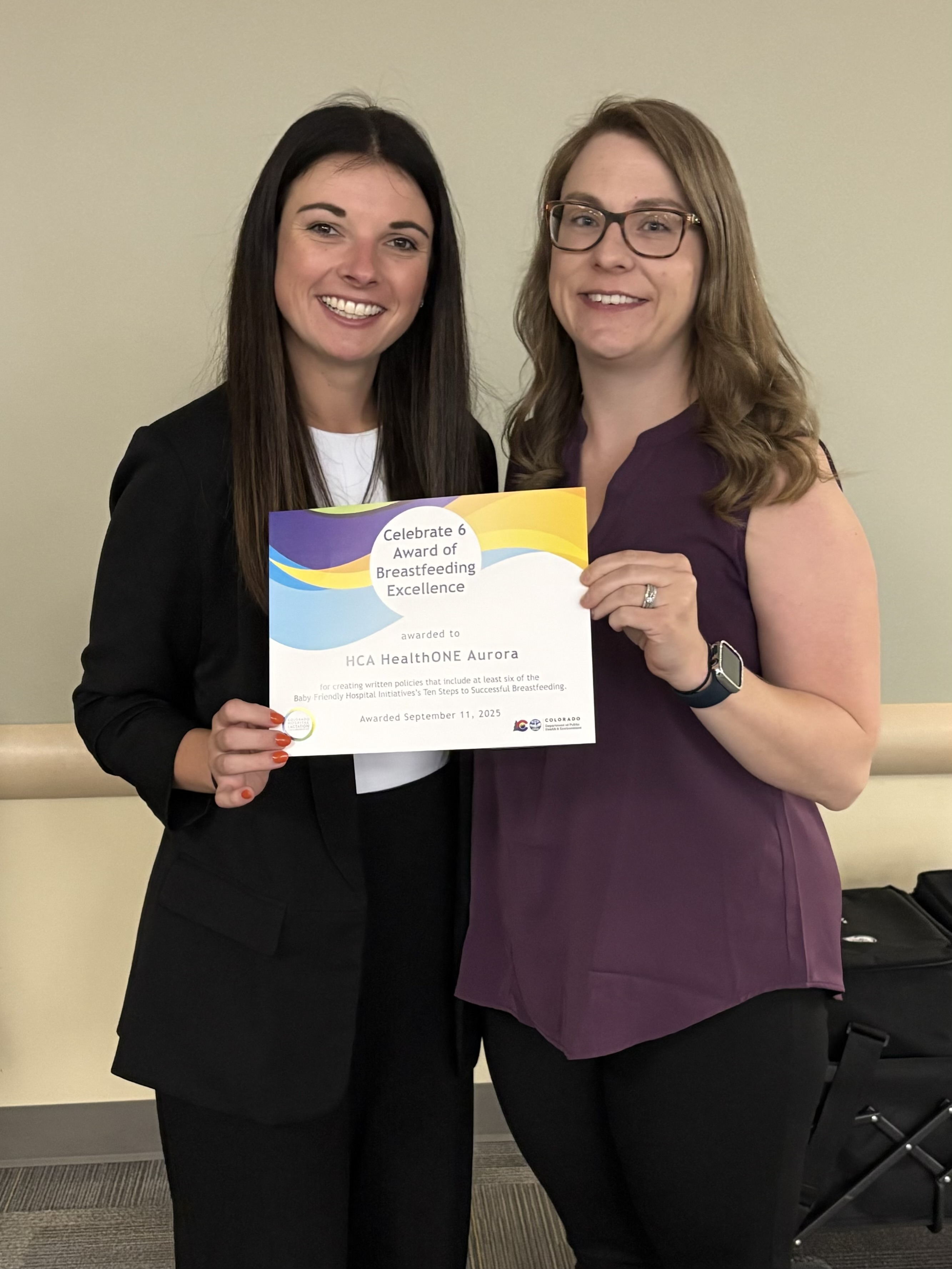 Two HCA HealthONE Aurora team members pose with 2025 Celebrate 6 Breastfeeding Excellence certificate.