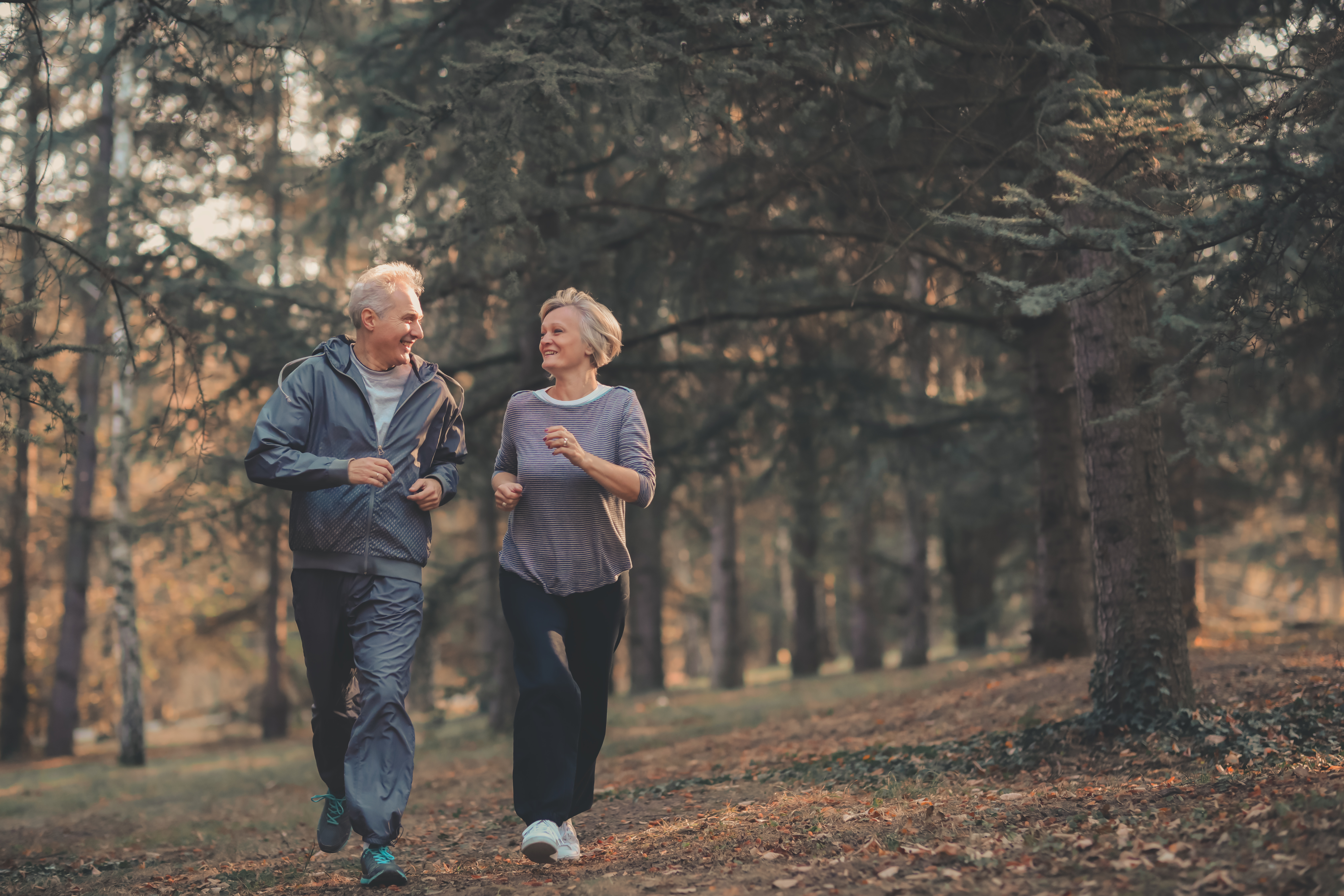 A mature happy couple is jogging outdoors