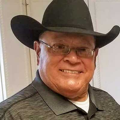 Hilario (Larry) Garcia wearing a black cowboy hat, smiling.