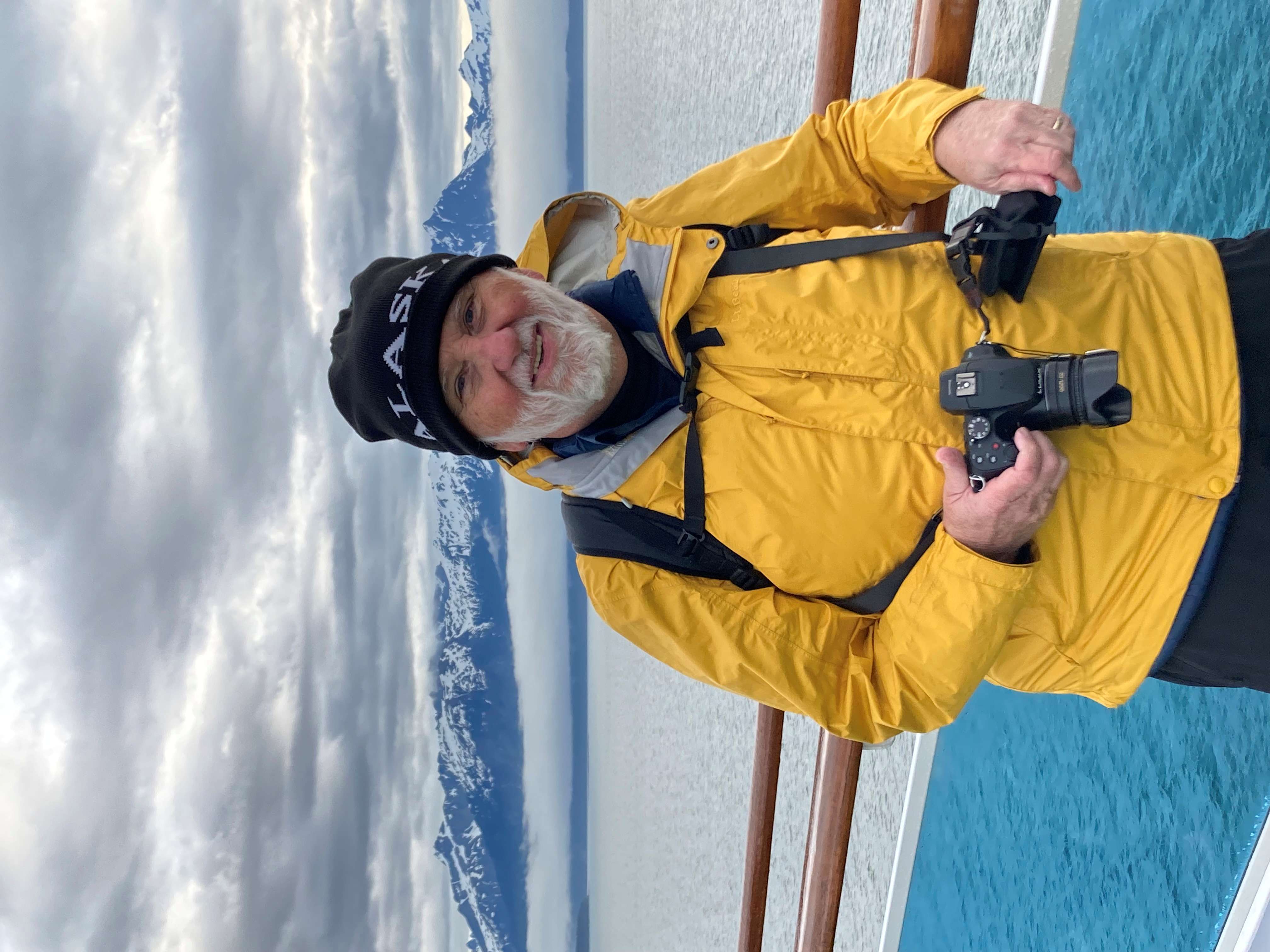 Bill Delia standing on the deck of a boat while holding his camera.
