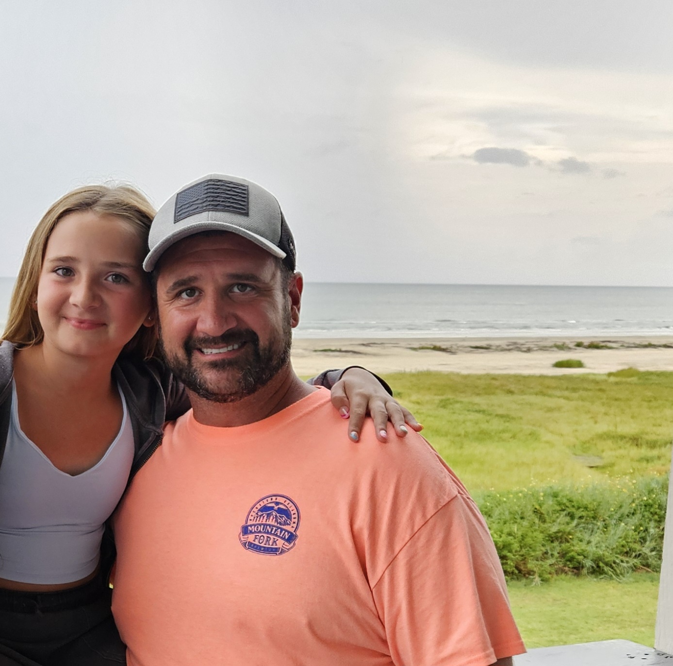 Jerry Farmer at the beach posing with his child