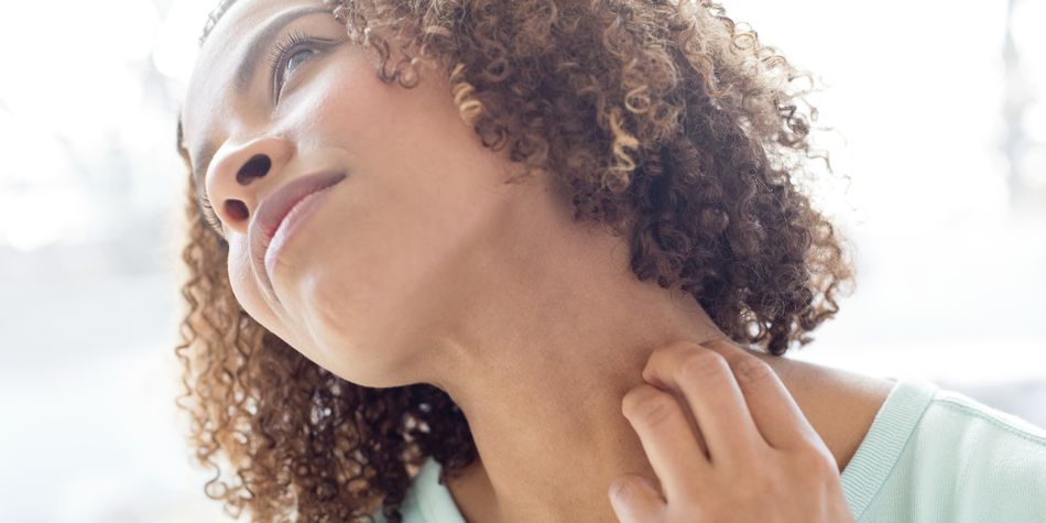 A woman scratching her neck.
