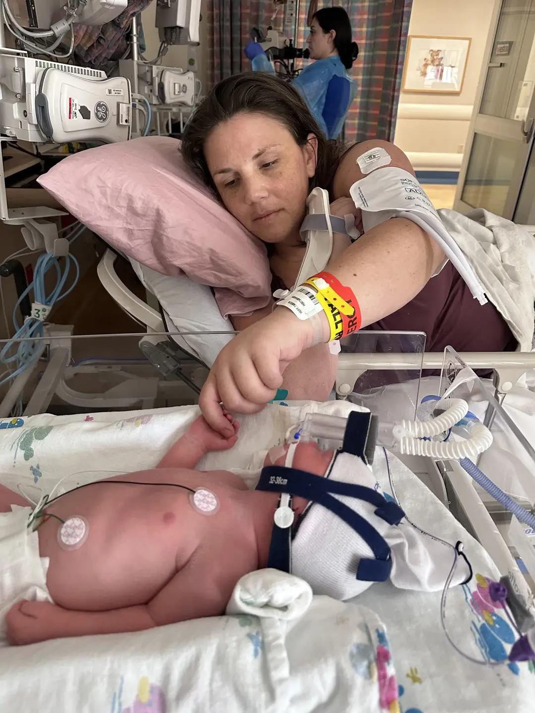 Tamsen Huff and her newborn baby in the hospital holding hands