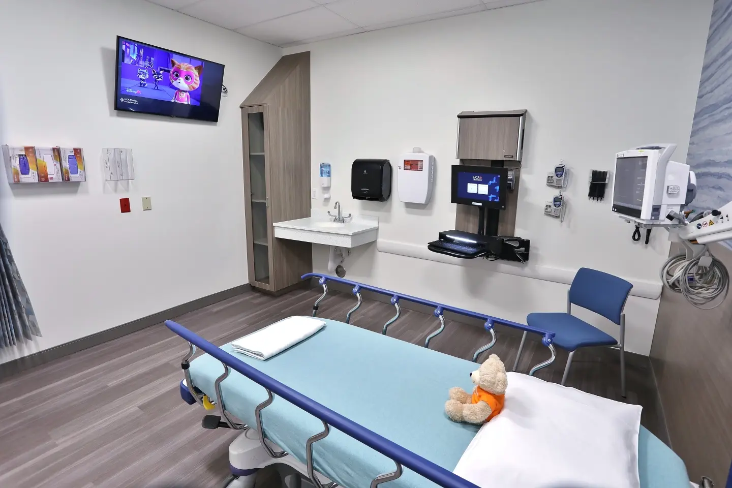 New pediatric room, with teddy bear on bed and mounted television.