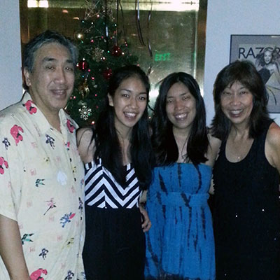 Harry Yee and his family pose for a picture in front of a Christmas tree.