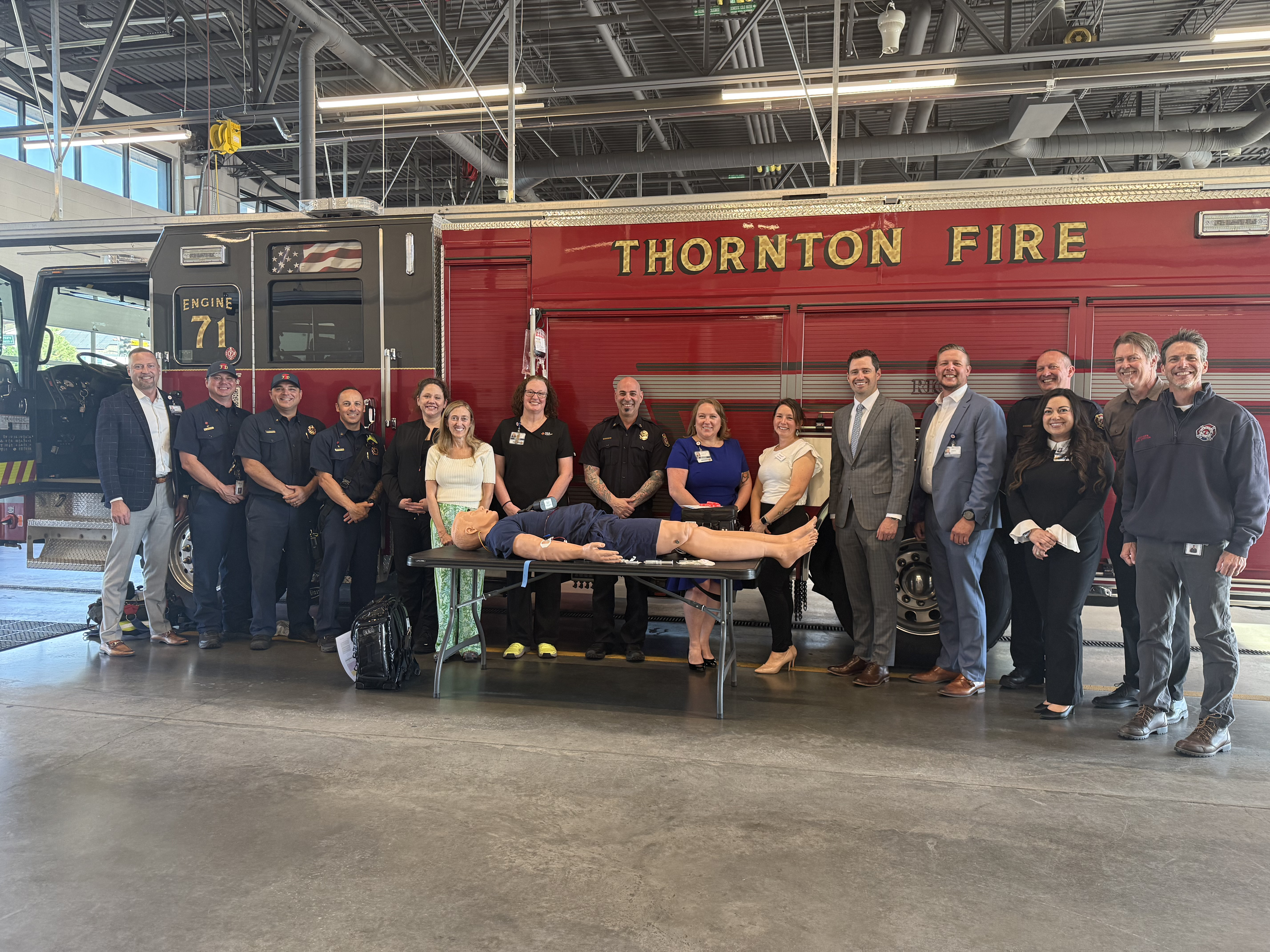The Thornton Fire Department standing in a group photo with HCA HealthONE Mountain Ridge staff, at the fire dept.