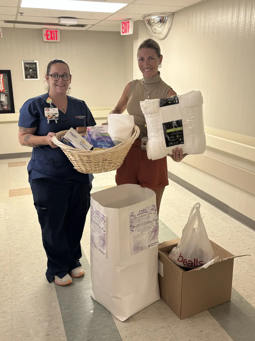 Photo of two females posing and smiling, showing essential donations for the mothers and children served by CASA (Community Action Stops Abuse).