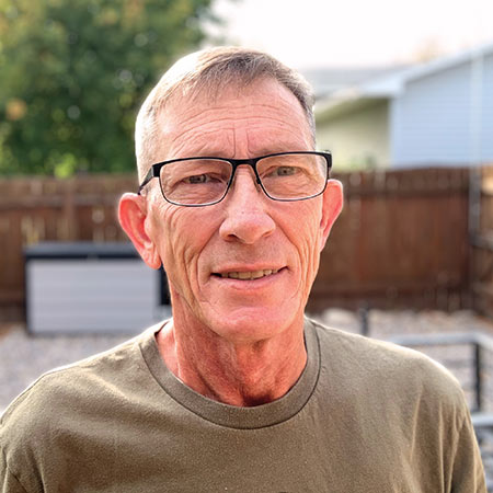 Brad Davis smiles while standing outdoors.