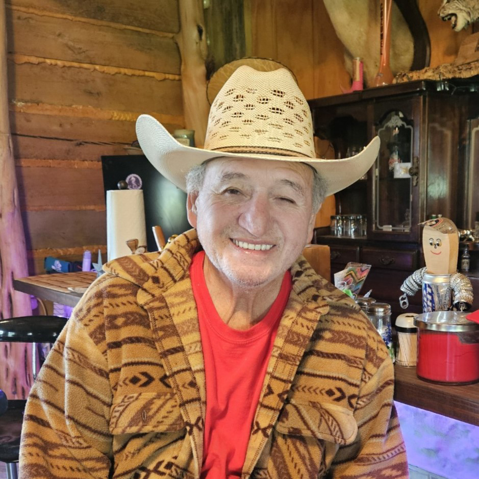 Armand Martinez wearing cowboy hat and smiling