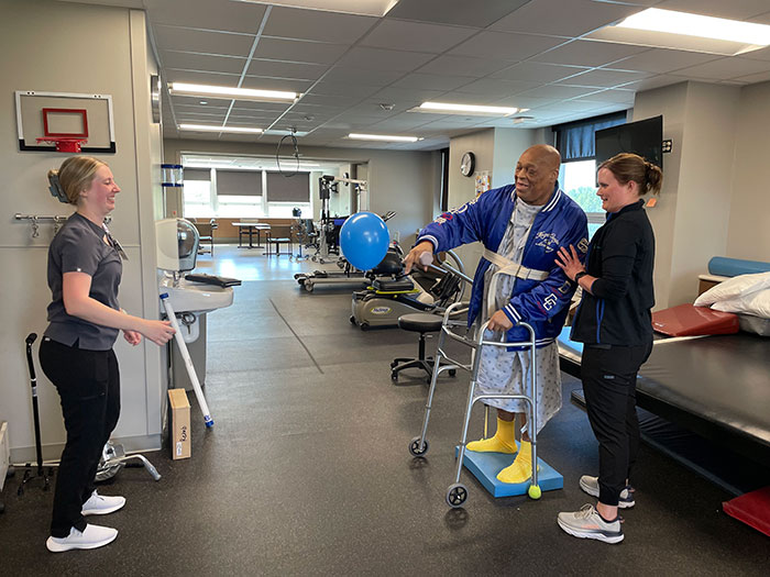 Thomas Edison laughs while working with his rehab team to improve his coordination.