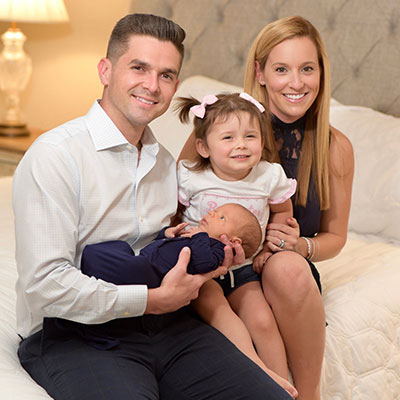 Mother Chrissie smiling with husband and young daughter