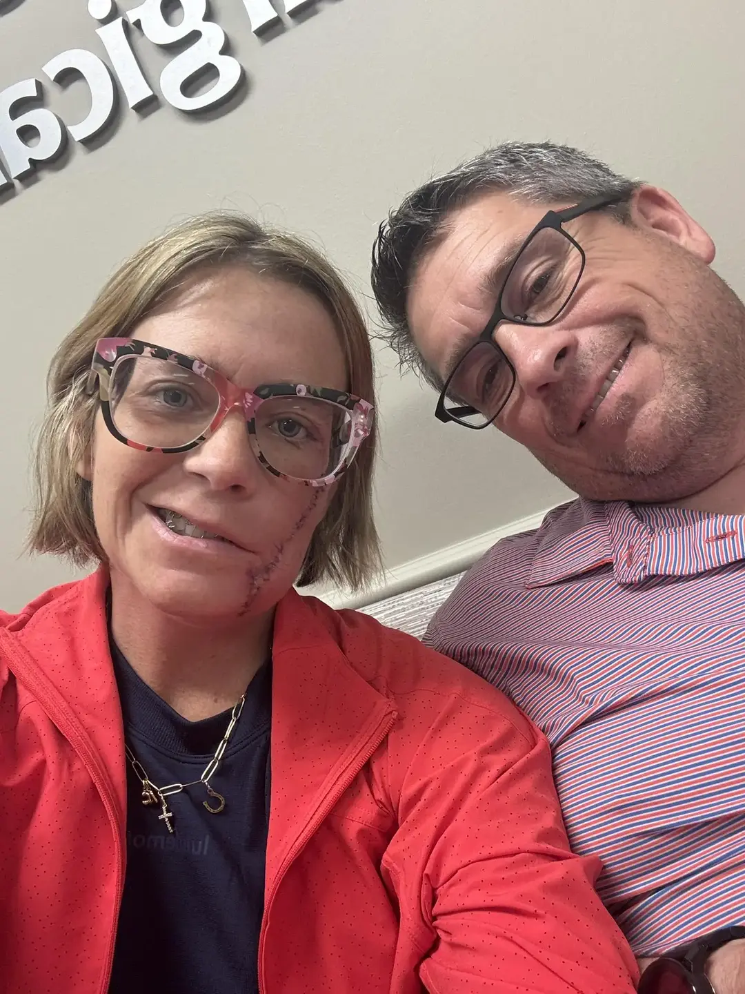 Lindsey Crouch selfie with husband in front of the Trauma ICU logo at TriStar Skyline